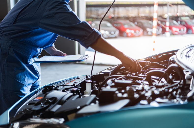 Mechanic holding clipboard checks engine during diagnostic inspection.